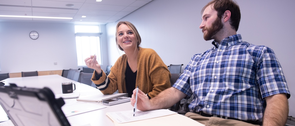 Two students working together at a table